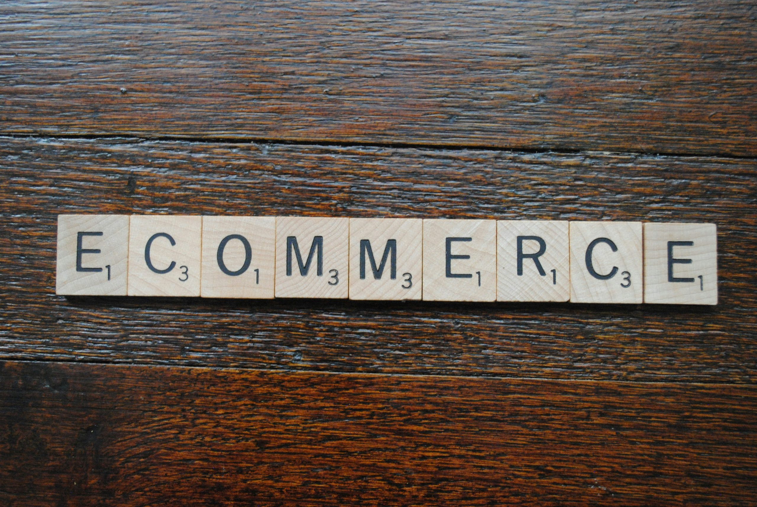 Ein Scrabble-Spiel auf einem Holztisch, das das Wort ECOMMERCE buchstabiert