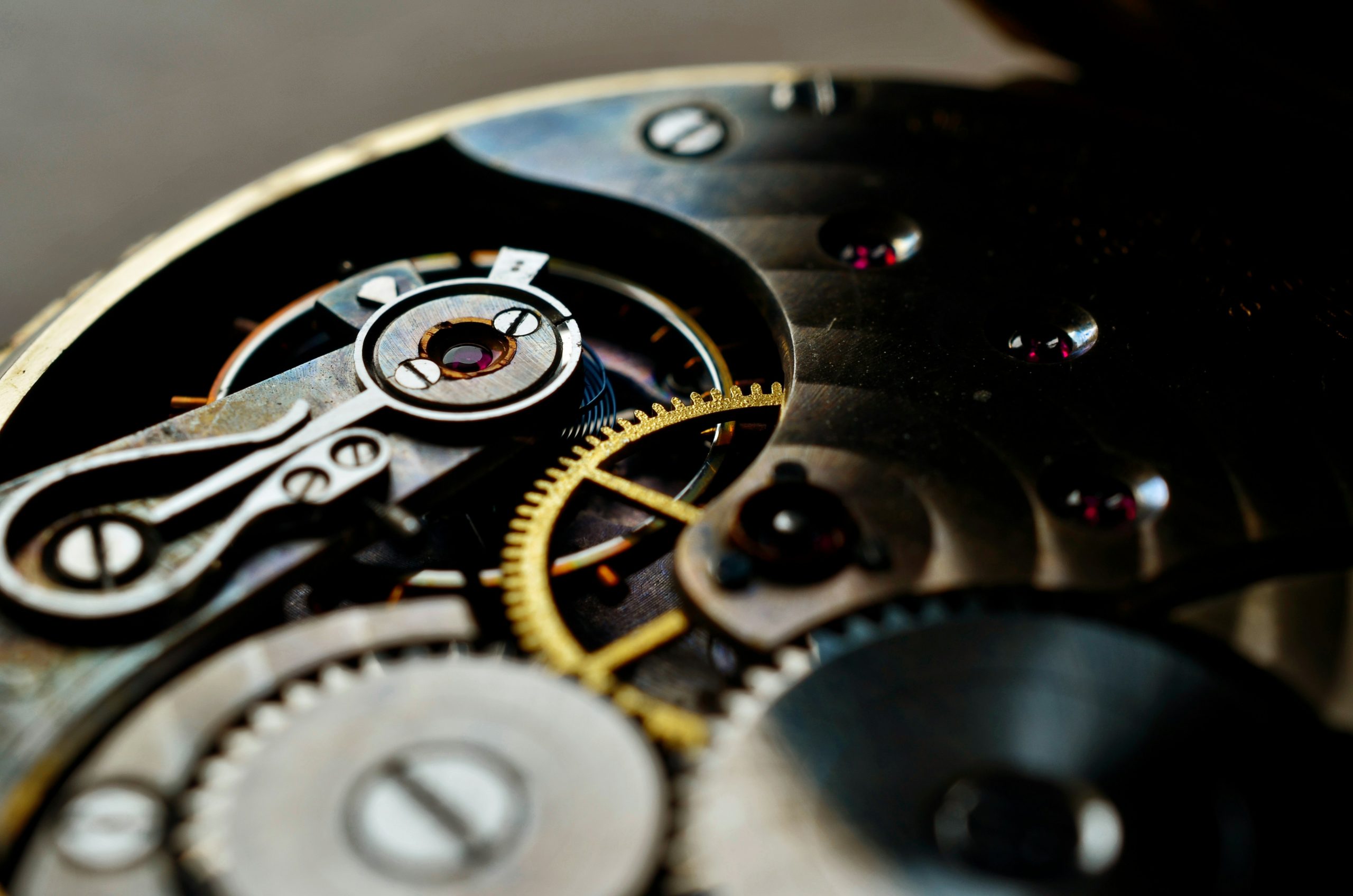 Ein goldenes Zahnrad in einem metallenen Uhrwerk im Close-up