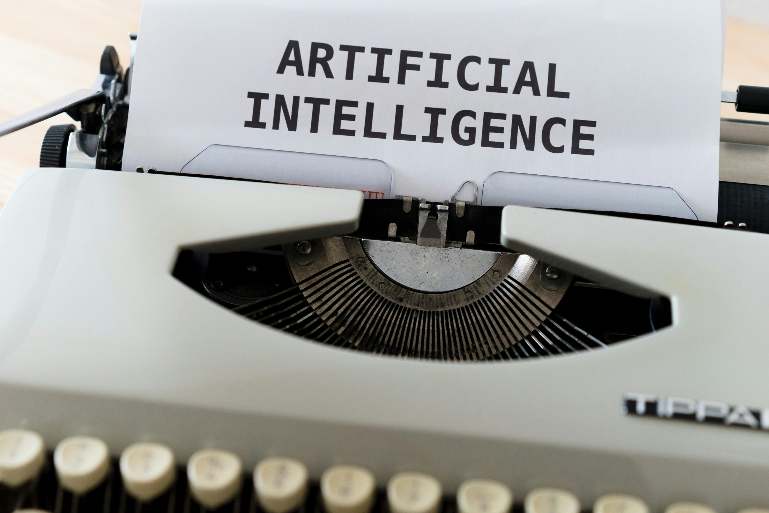 Eine Schreibmaschine mit einem Zettel auf dem Artificial Intelligence geschrieben wurde