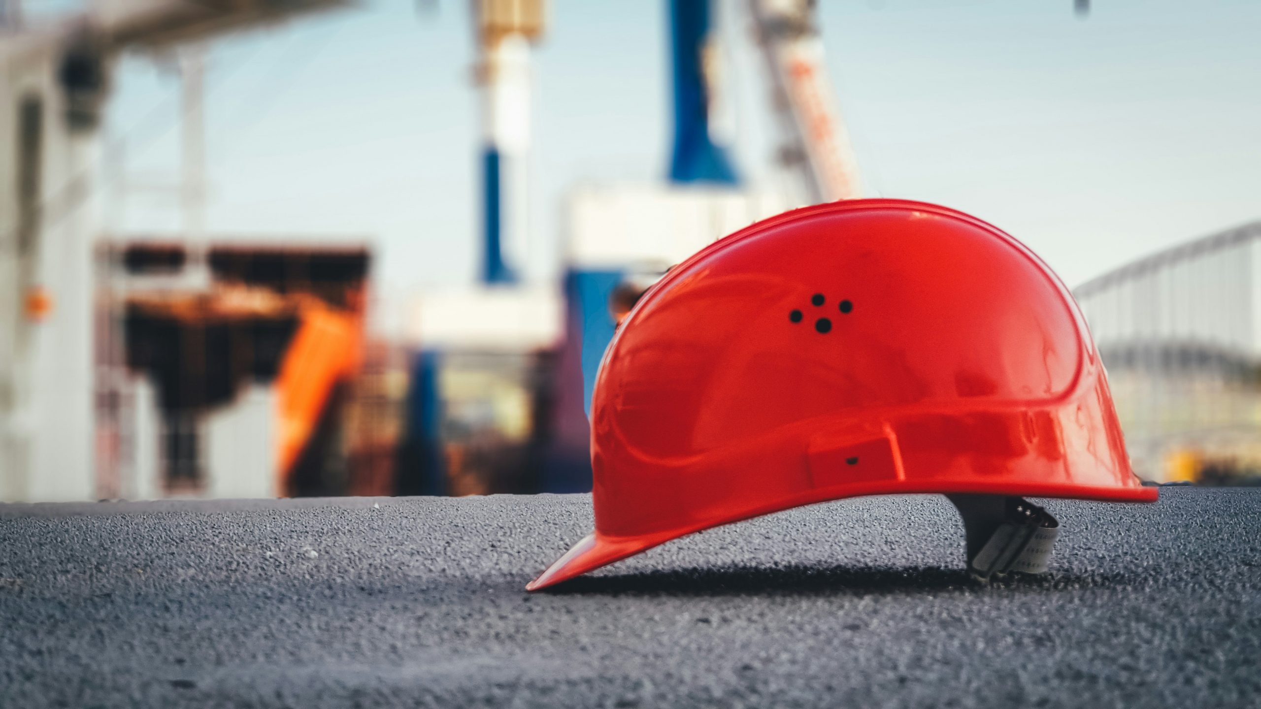 Ein roter Helm im Close-Up liegt auf dem Boden einer Hafenanlage