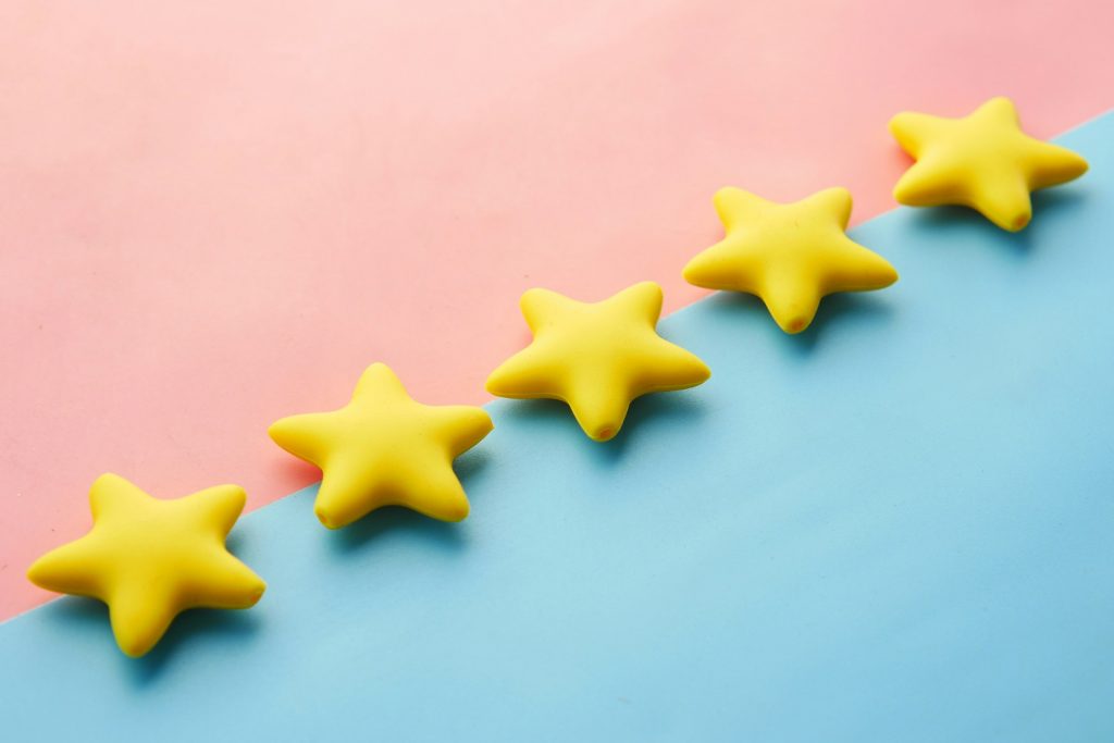 eine-reihe-gelber-sterne-die-auf-einer-blauen-und-rosa-oberflache-sitzen