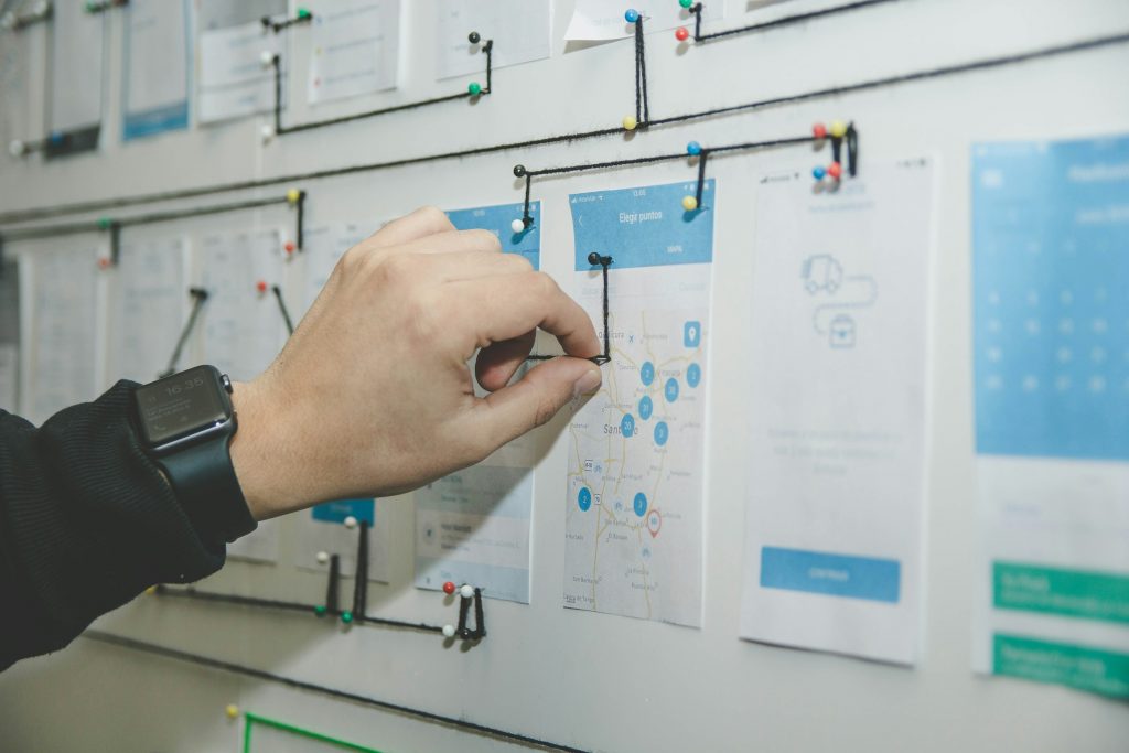 Person die an Whiteboard blaue und weiße Notizen verbindet