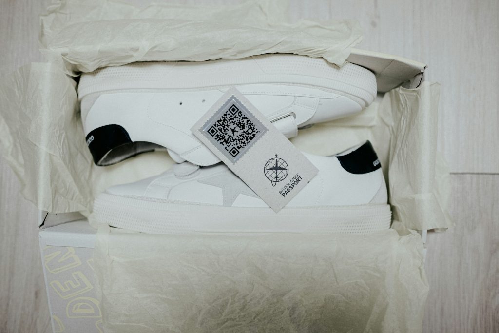 ein paar weiße turnschuhe in einer schachtel mit qr code als produktpass