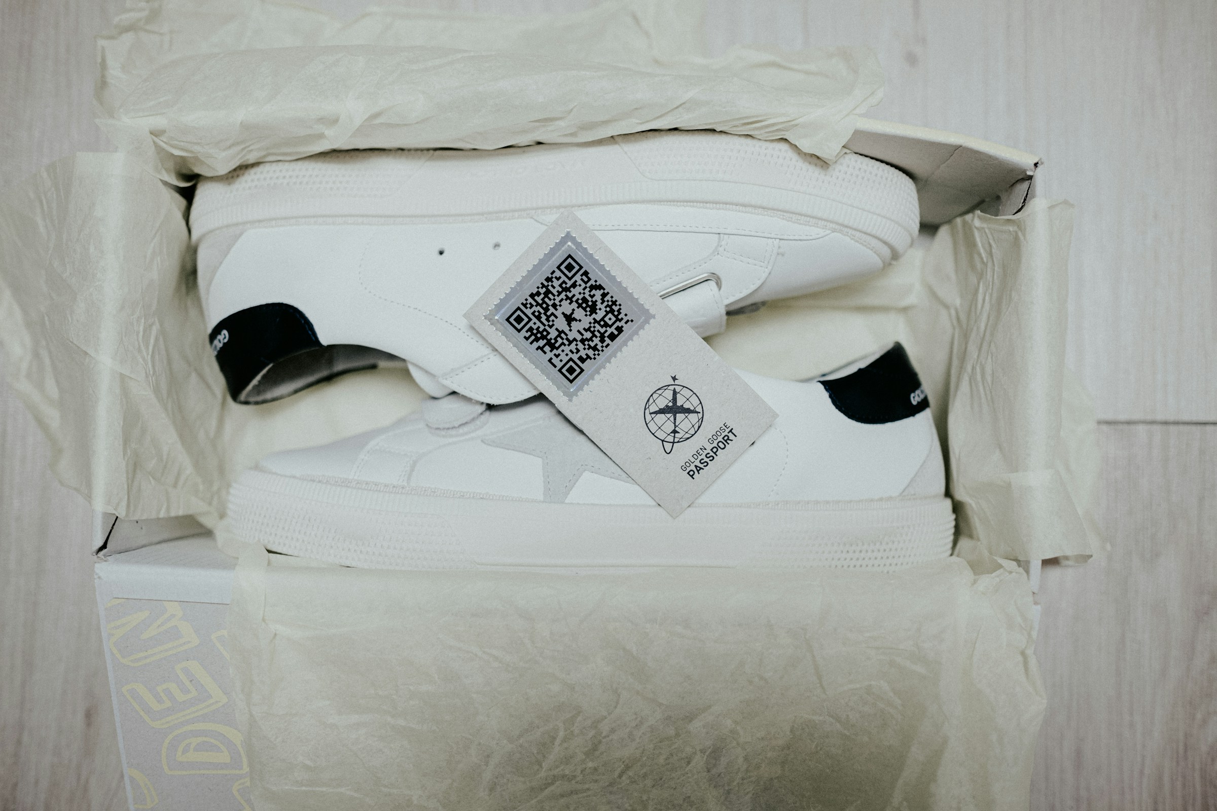 ein paar weiße turnschuhe in einer schachtel mit qr code als produktpass
